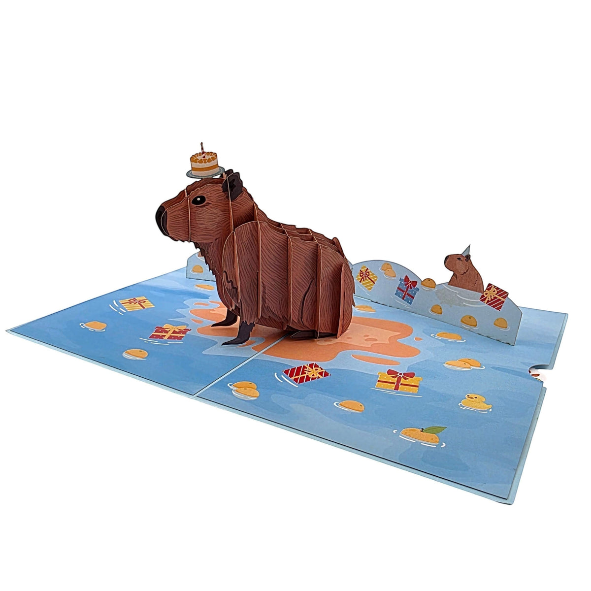Color Pop Cards 3D pop-up birthday card featuring a brown capybara with a cake on its head, surrounded by gifts and confetti.