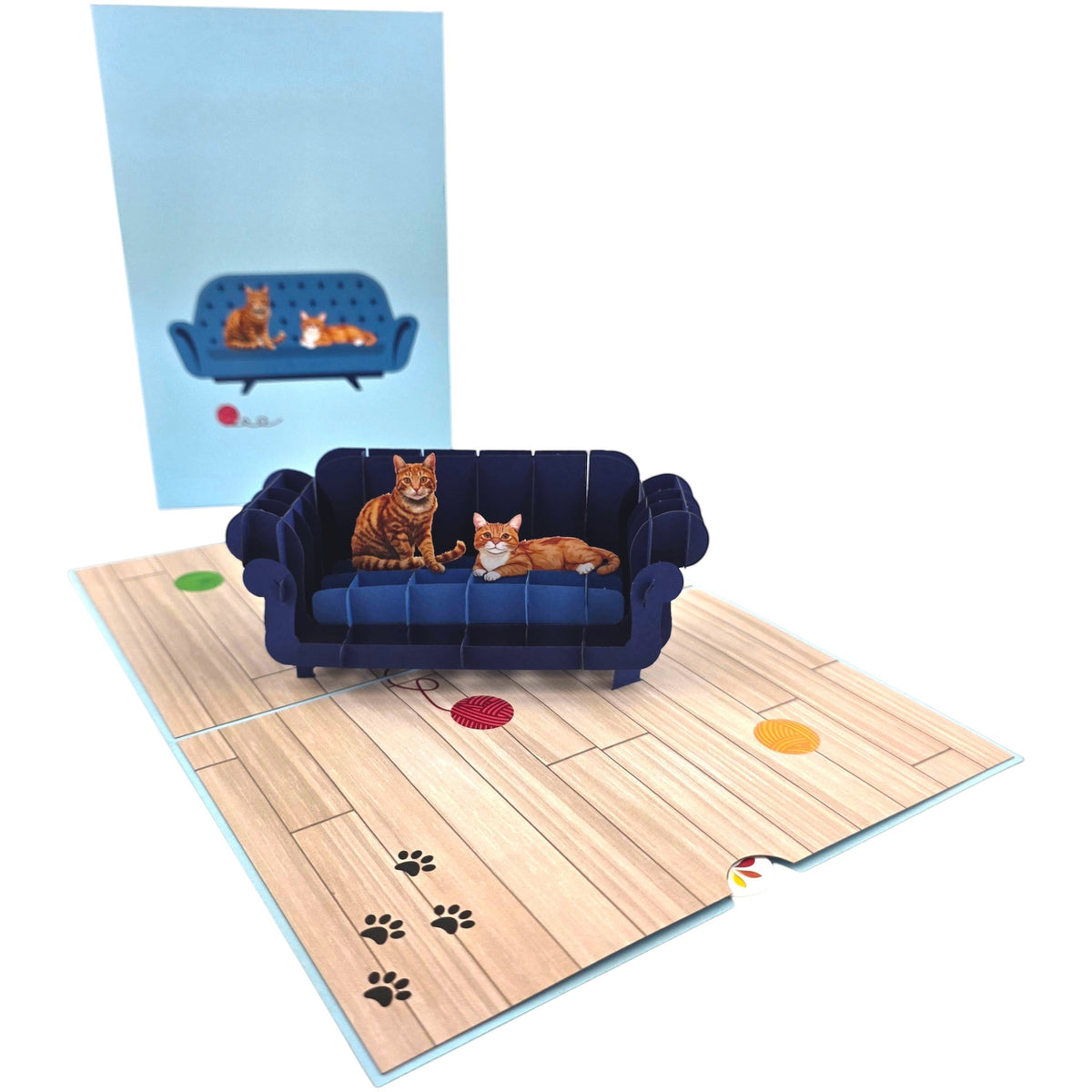 Color Pop Cards blue pop-up card featuring two ginger cats on a navy sofa, with paw prints and yarn balls on the floor.