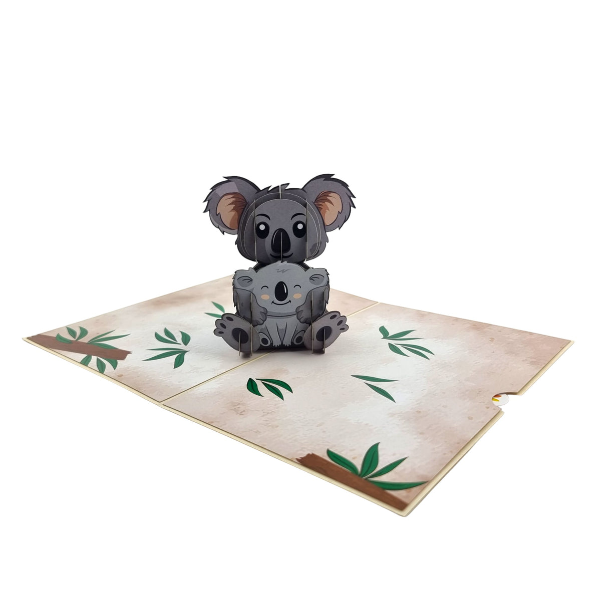 Color Pop Cards Koala Family pop-up card with two grey koalas sitting on a textured paper background with green leaves.