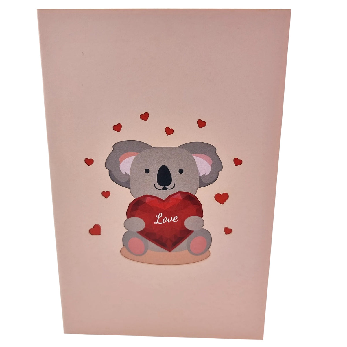 Color Pop Cards pop-up card featuring a cute koala holding a faceted red heart with the word "Love" on it. Surrounded by small red hearts.