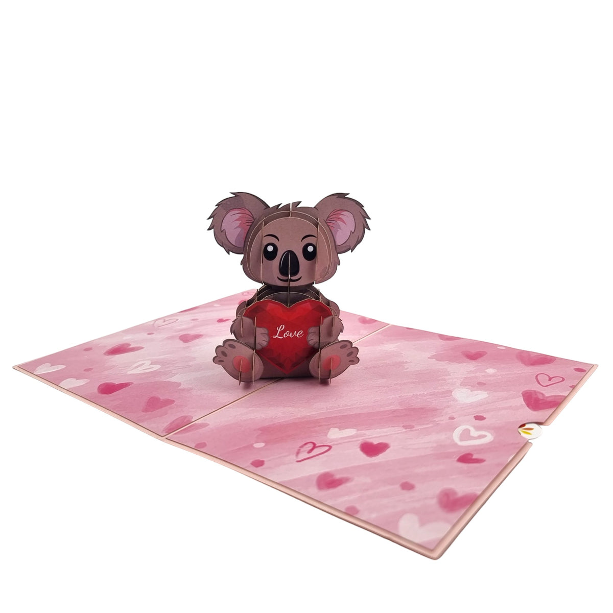 Color Pop Cards pop-up card featuring a cute koala holding a red heart with the word "Love" on it. The card has a pink watercolor background with scattered hearts.