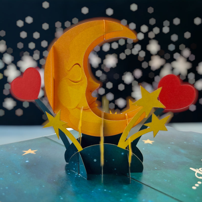 Color Pop Cards Love You To The Moon and Back pop up card with a smiling crescent moon, red hearts, and yellow stars.