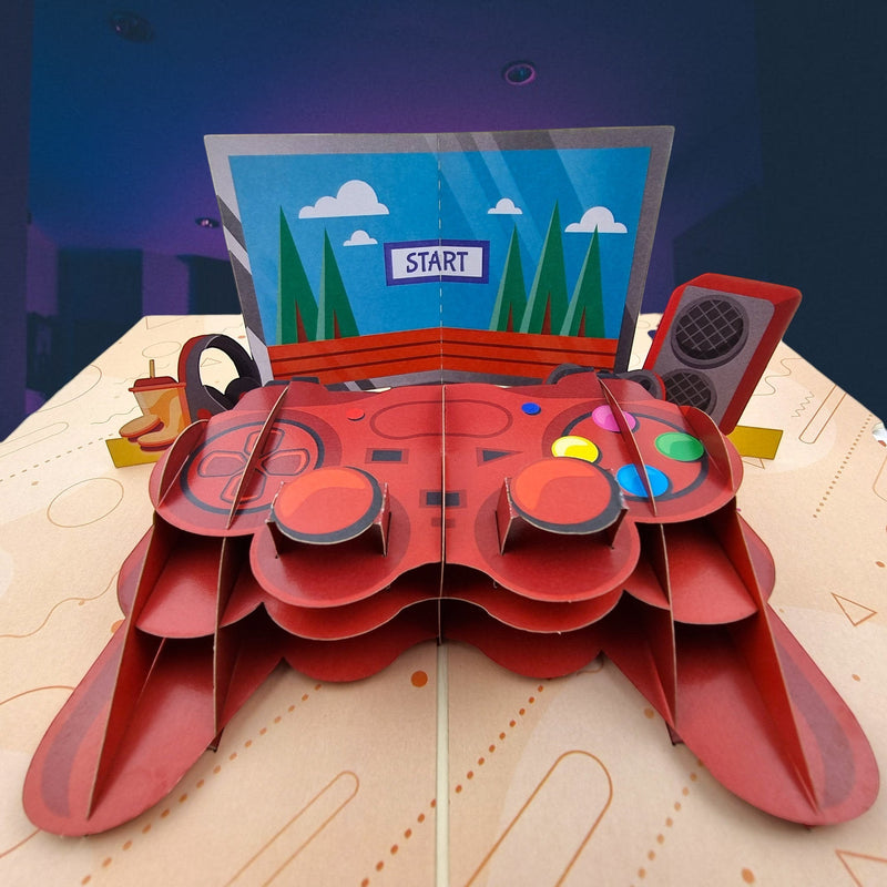 Color Pop Cards red video game controller pop-up card with "START" screen, headphones, and speakers.