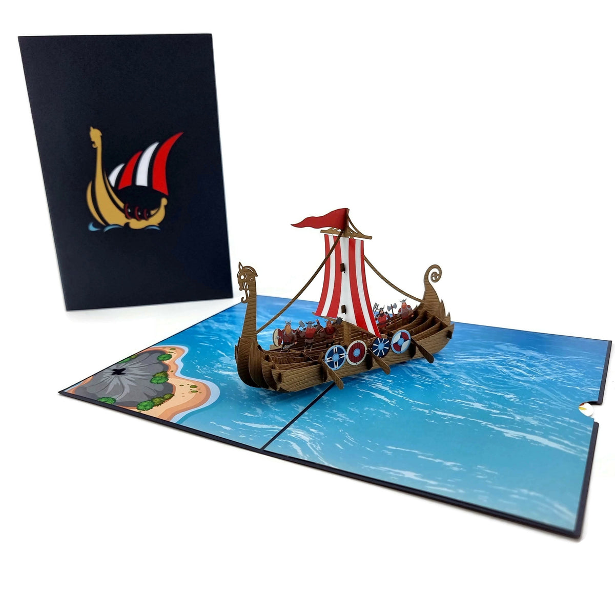 Color Pop Cards Viking ship pop-up card with red and white striped sails, detailed shields, and dragon bow. Features a 3D wooden boat on a blue ocean scene.